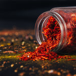 Load image into Gallery viewer, A still life photo of pink saffron flakes, one of the key fragrance notes in the &quot;Citrus and Peppercorn&quot; scented candle from Tuscany Candle&#39;s &quot;Homme &amp; Heritage&quot; collection of manly candles
