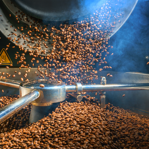 A photo of roasting coffee beans in the hopper of a coffee roaster. Coffee is one of the main fragrance notes in the "Cafe au Lait" candle from Tuscany candle.