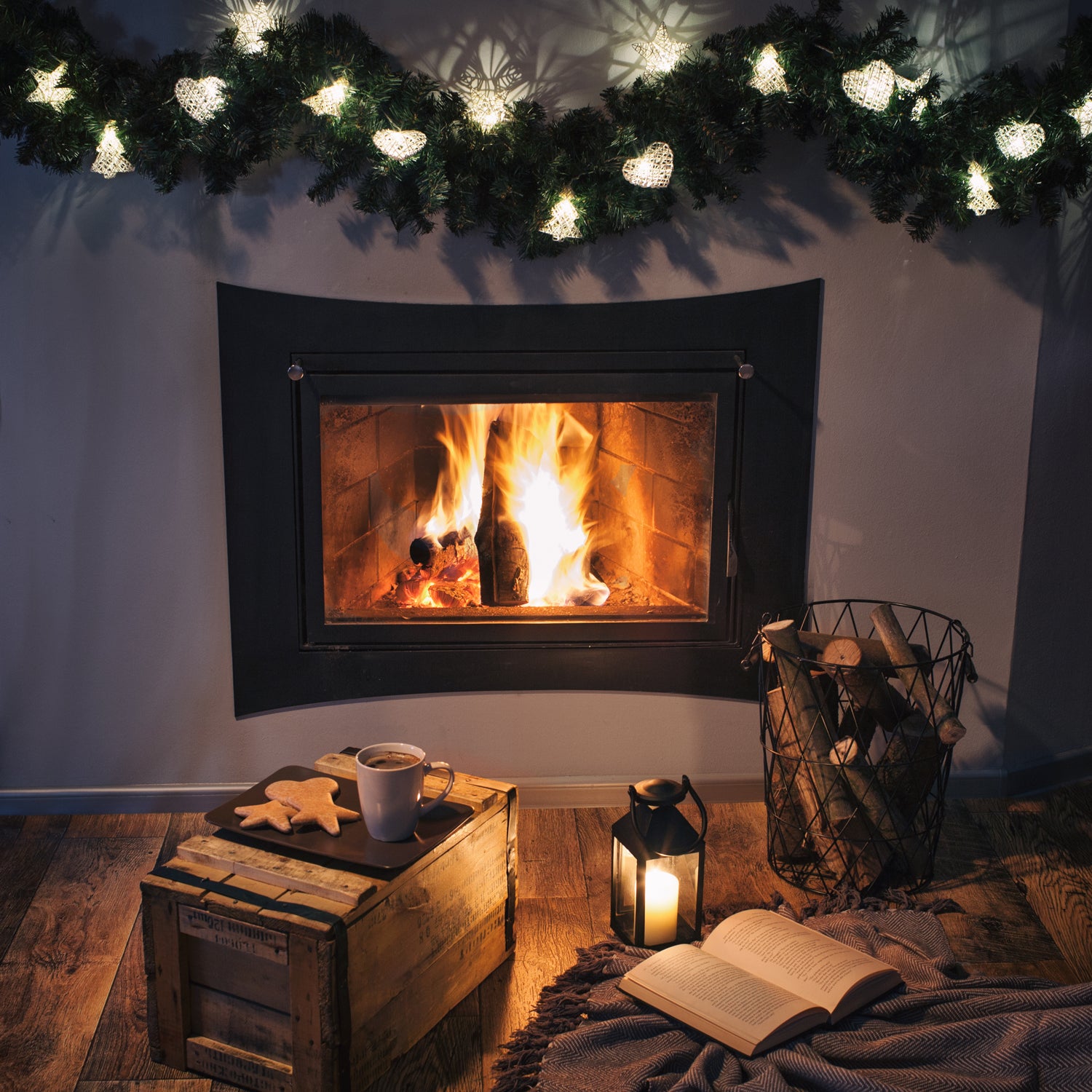 A rustic Tuscany Candle fireplace adorned with Christmas lights and a book, exuding the cozy farmhouse charm of the holiday season.