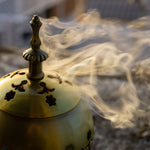 Load image into Gallery viewer, An incense burner filled with sandalwood - one of the fragrance inspirations for the &quot;Bronzed Fireside&quot; scented candle from Tuscany Candle
