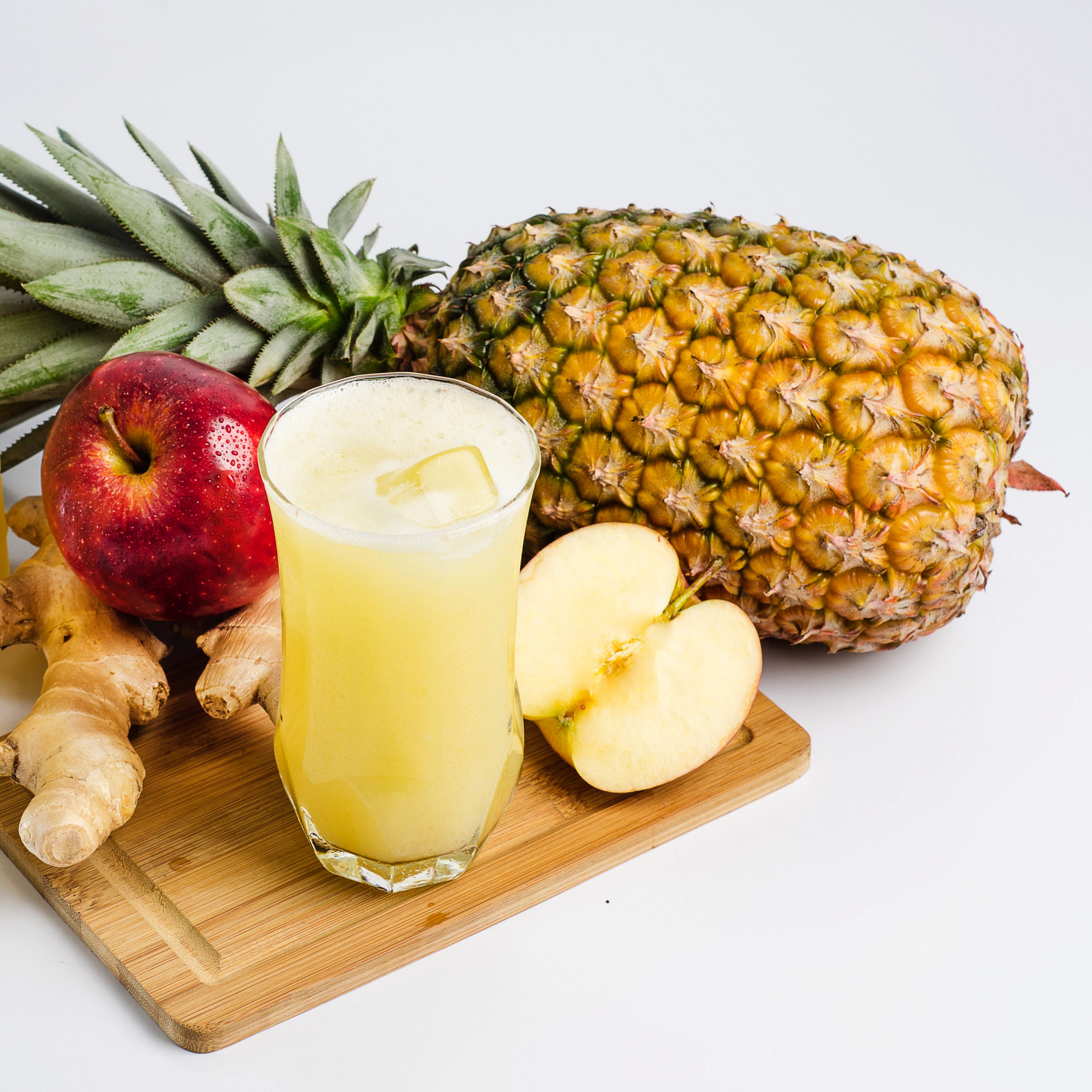 A Pineapple Ginger scented wax melt from Tuscany Candle® featuring the delightful aromas of pineapple, apple, and ginger on a cutting board.