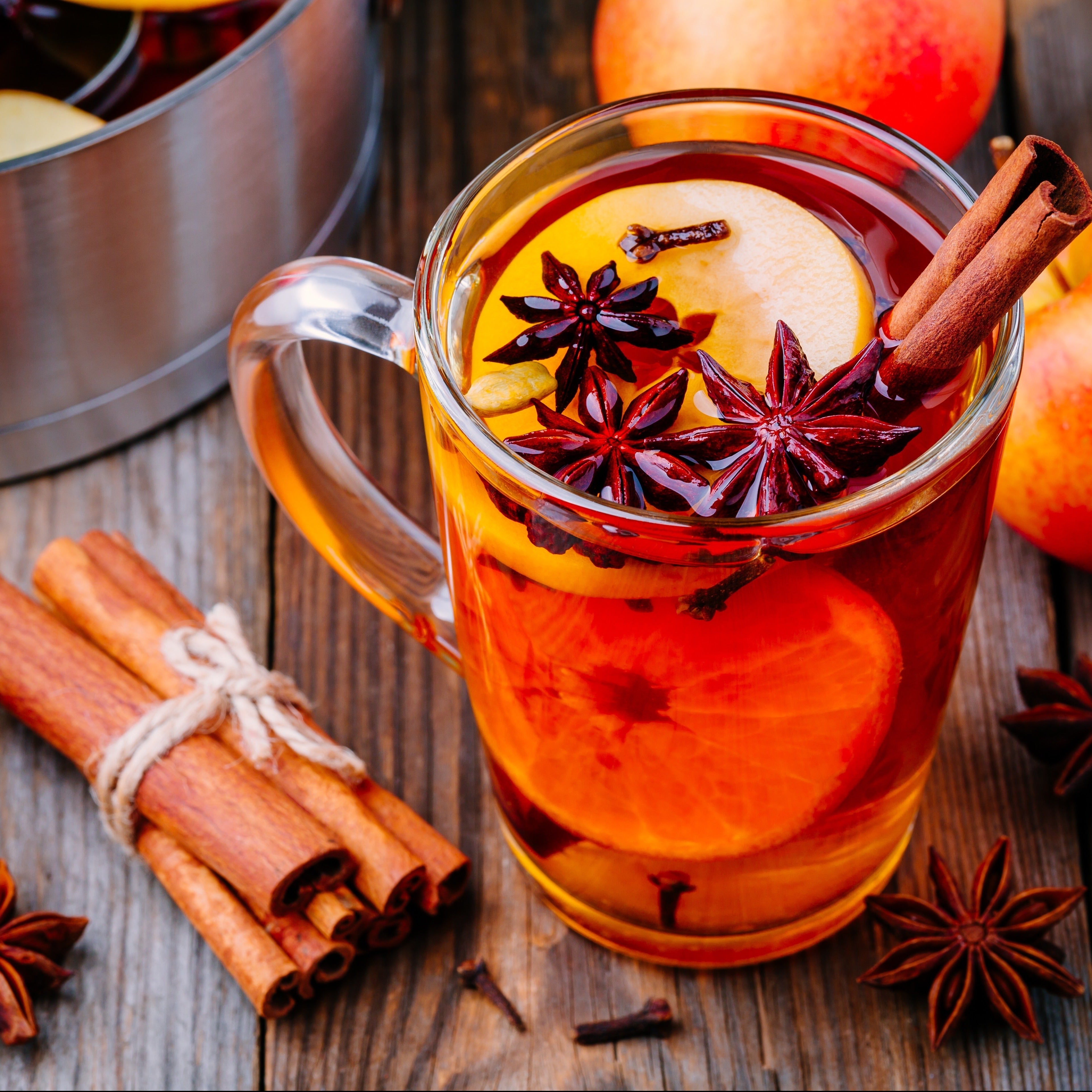 A Citrus Clove Cider scented wax melt (2.5 oz) from Tuscany Candle®, emitting the warm fragrance notes of mulled cider, accompanied by cinnamon sticks and apples.