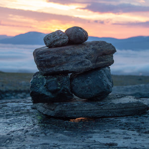 A photo of tranquil stacked rocks warming on a cold mountain morning, which is a sensation we are trying to evoke with our "Tundra Meditiation" scented candle